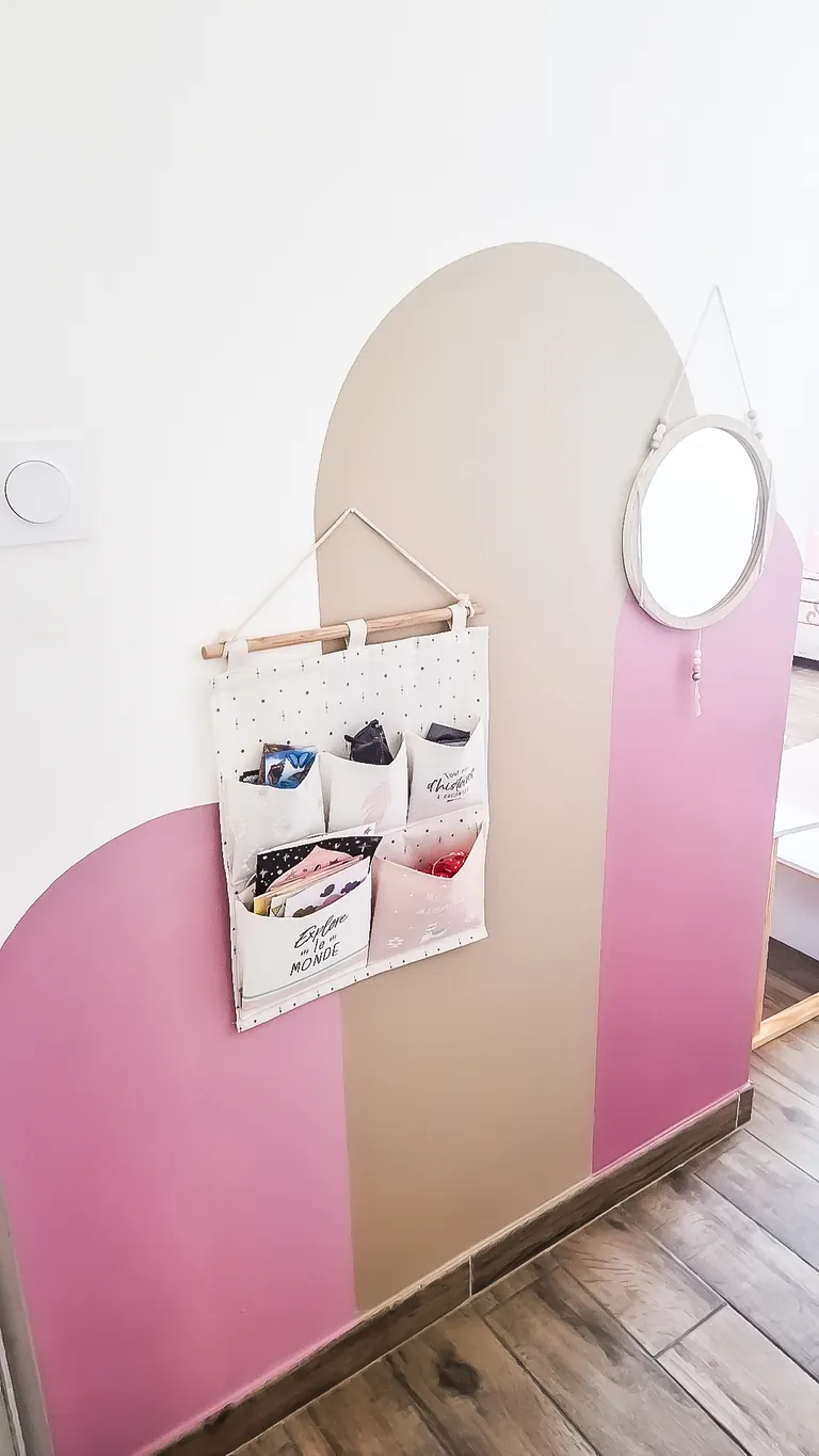 Mur décoratif à arches peintes rose et sable